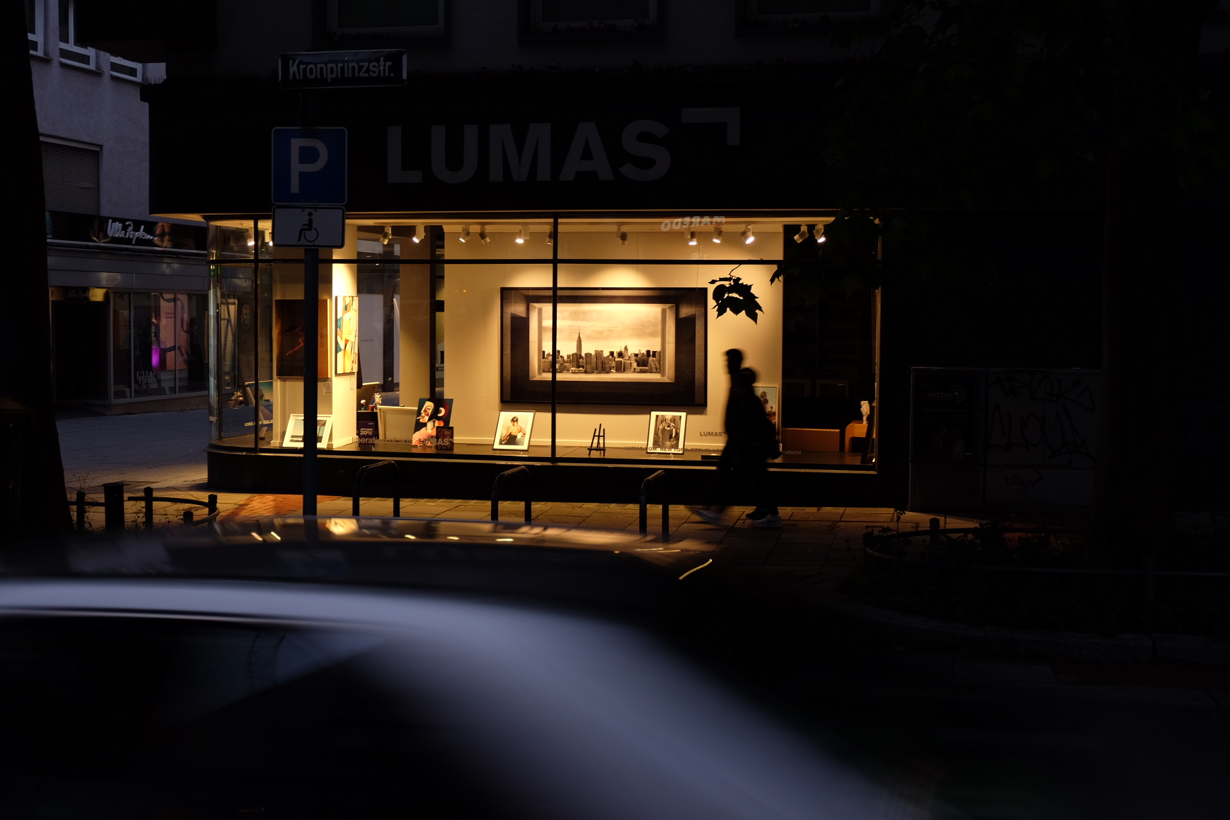 Night street scene with a lit gallery window