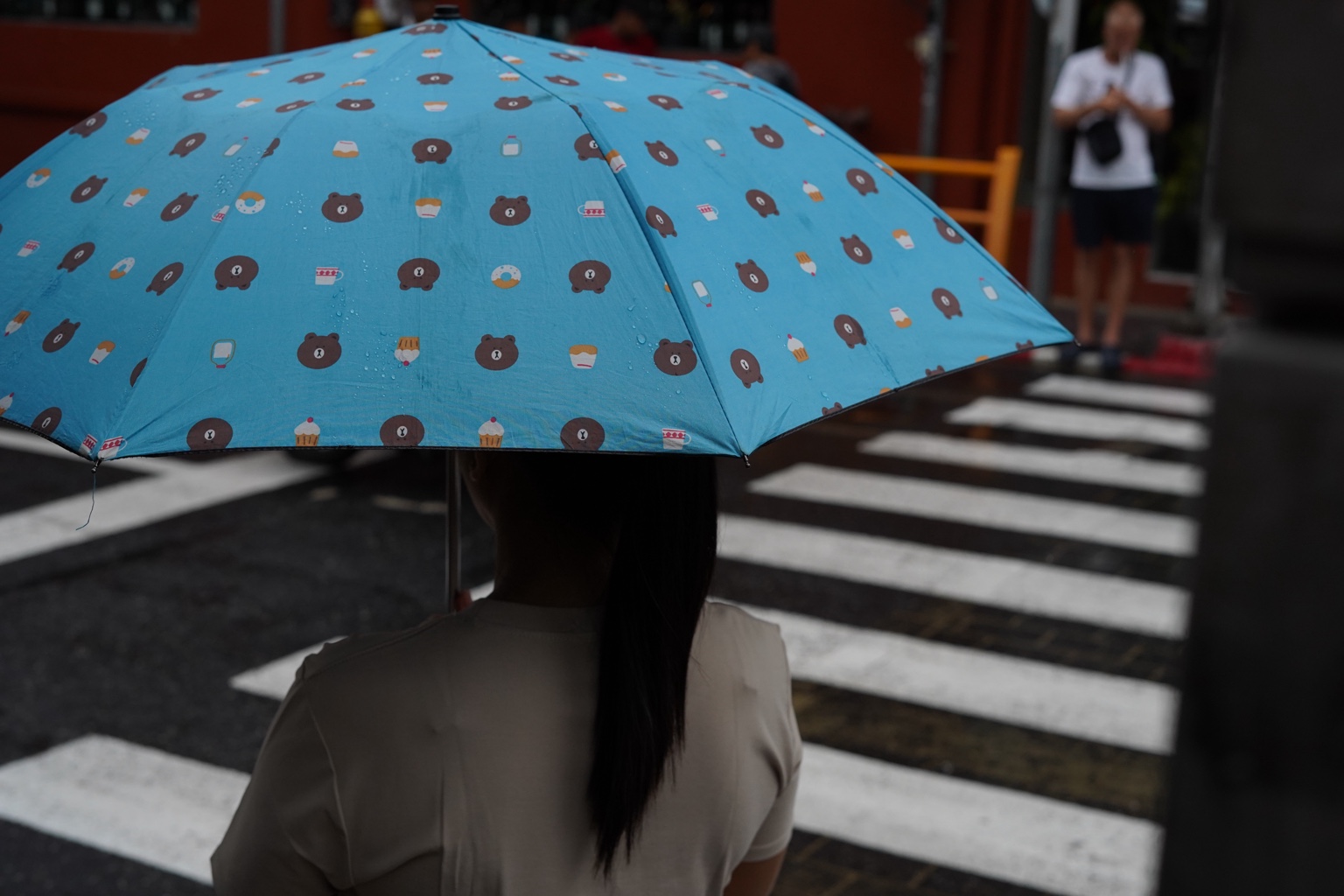 Blue umbrella at a city crosswalk