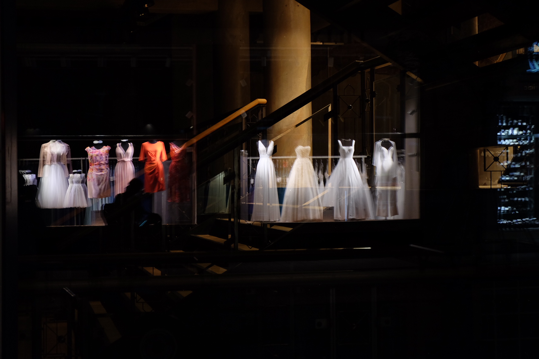 Illuminated dresses in a dark shop window