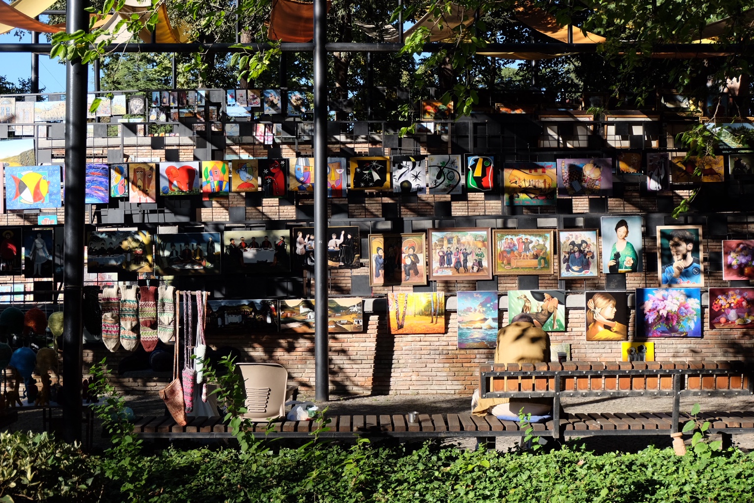 Outdoor wall filled with paintings and sunlight