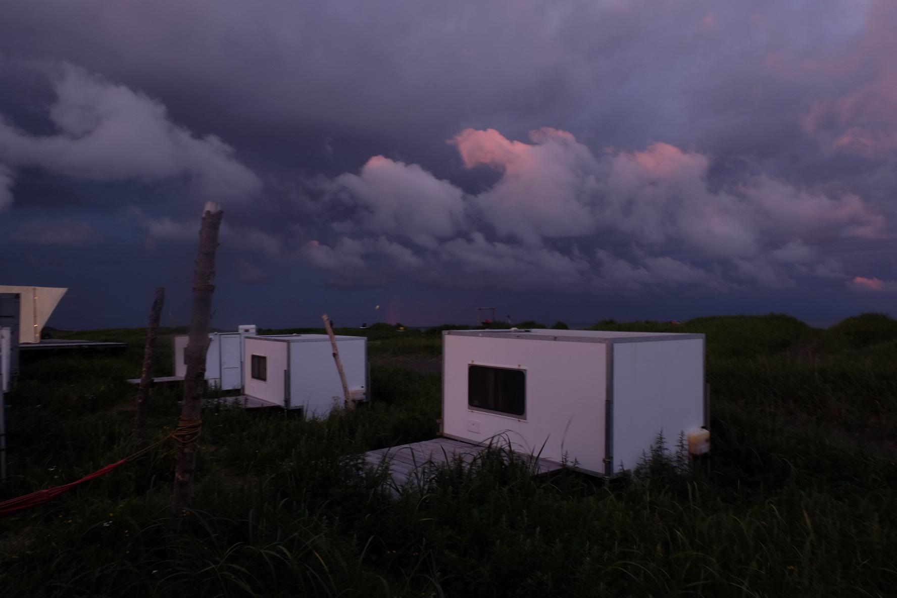 Purple storm clouds above small white cabins