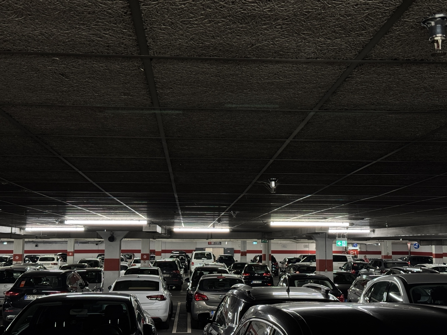 Cars parked under a low dark ceiling in an underground garage