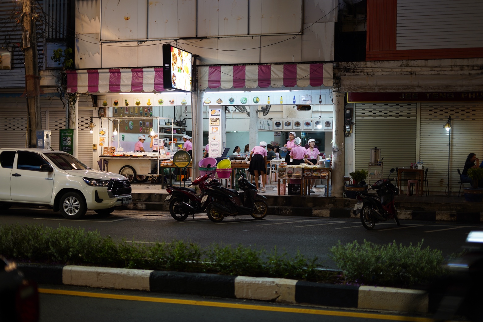 Bright night food stall with workers in pink uniforms